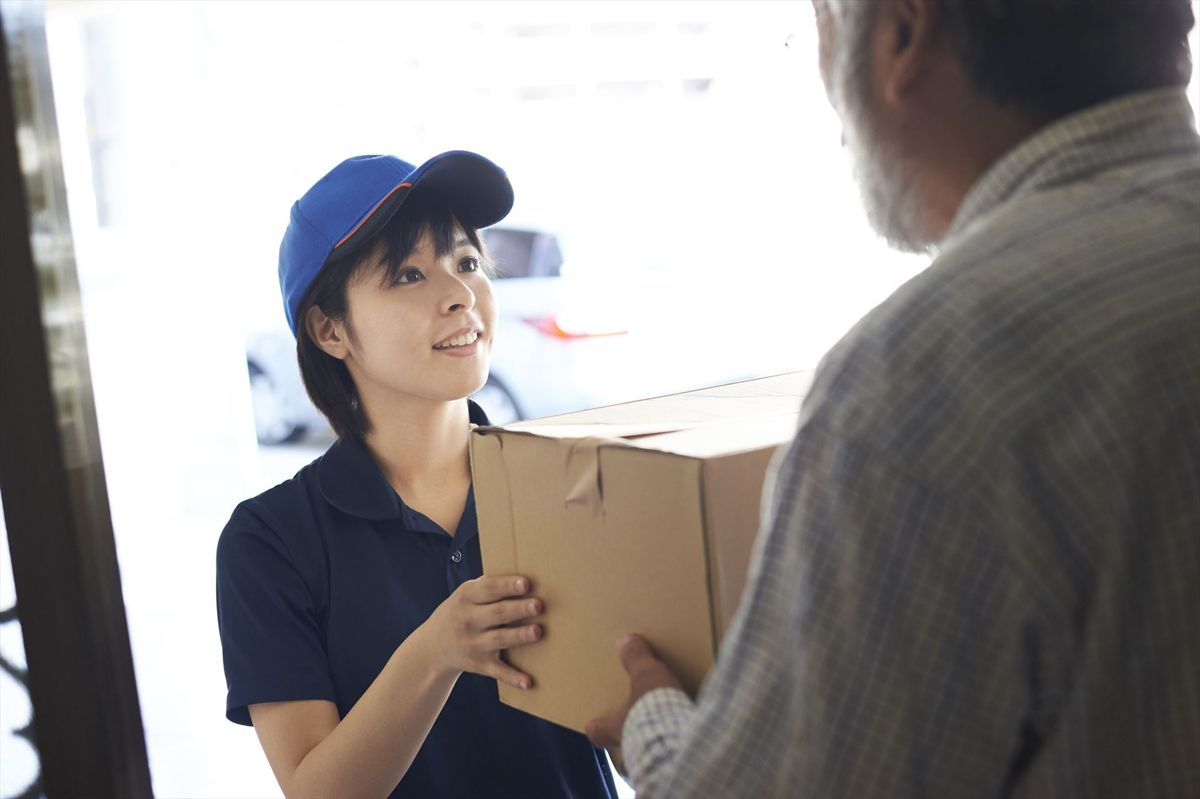 荷物を手渡すドライバー